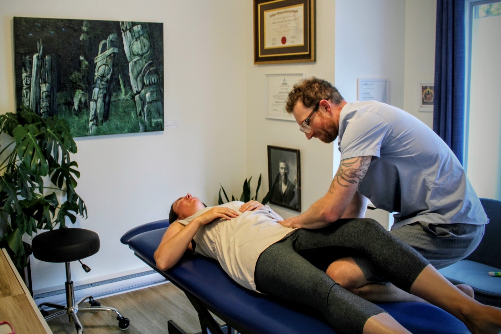 James Boyce performing manual osteopathic work on a client's lower back and hip.
