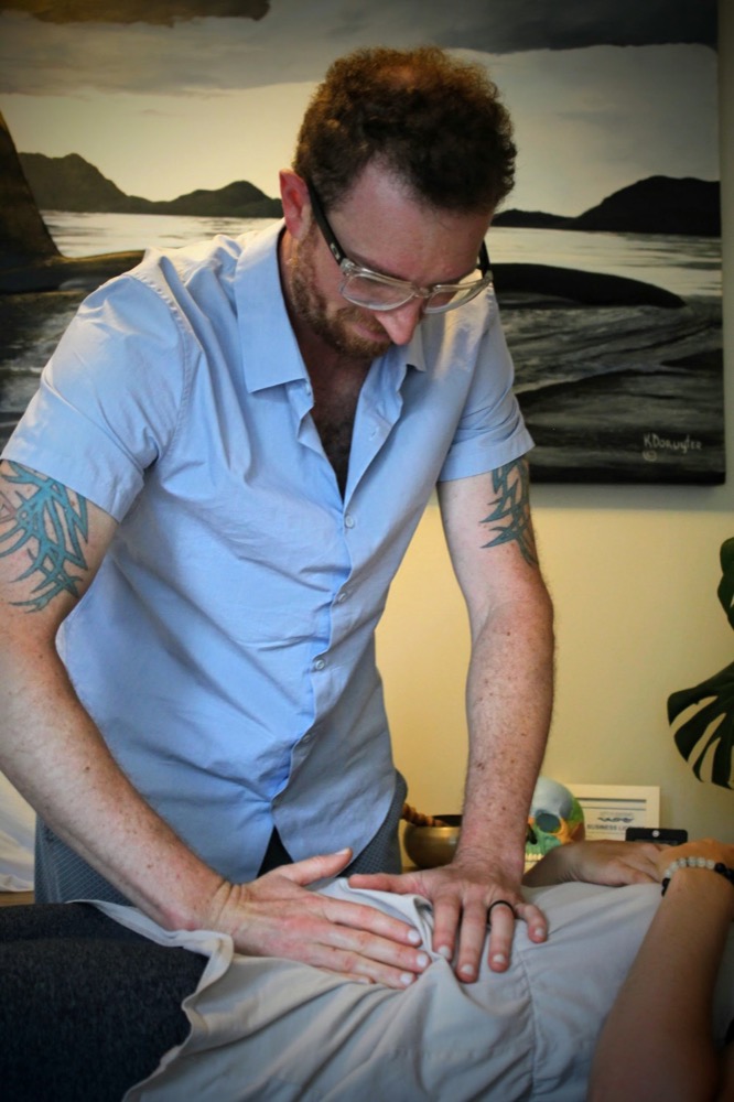 James Boyce performing gentle abdominal osteopathic work on a client.