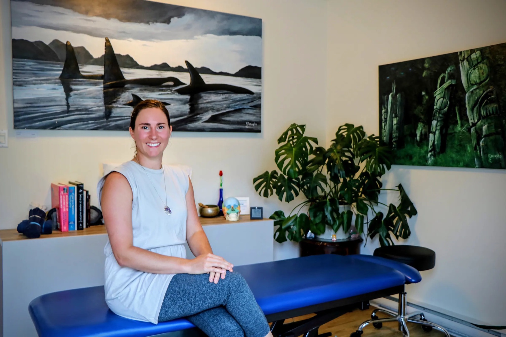 Kayla Larsen sitting in her treatment room at Multidimensional Health, smiling.
